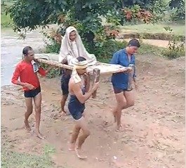 उफनते नाले के बीच मरीज को खाट पर ले जाने की मजबूरी